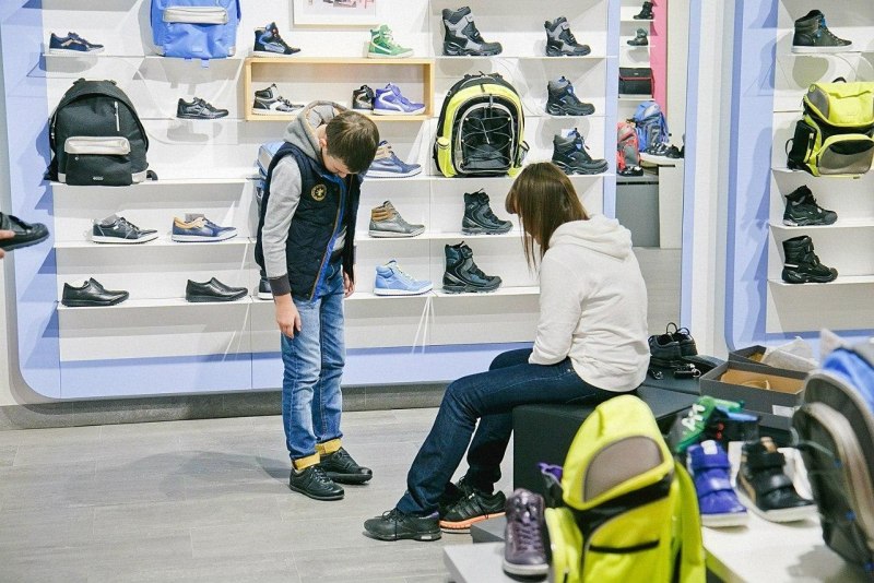 Дети меряют обувь в магазине